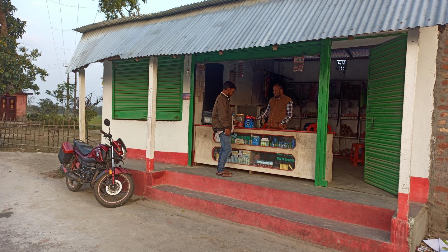 A shop owner sells items to a customer in India