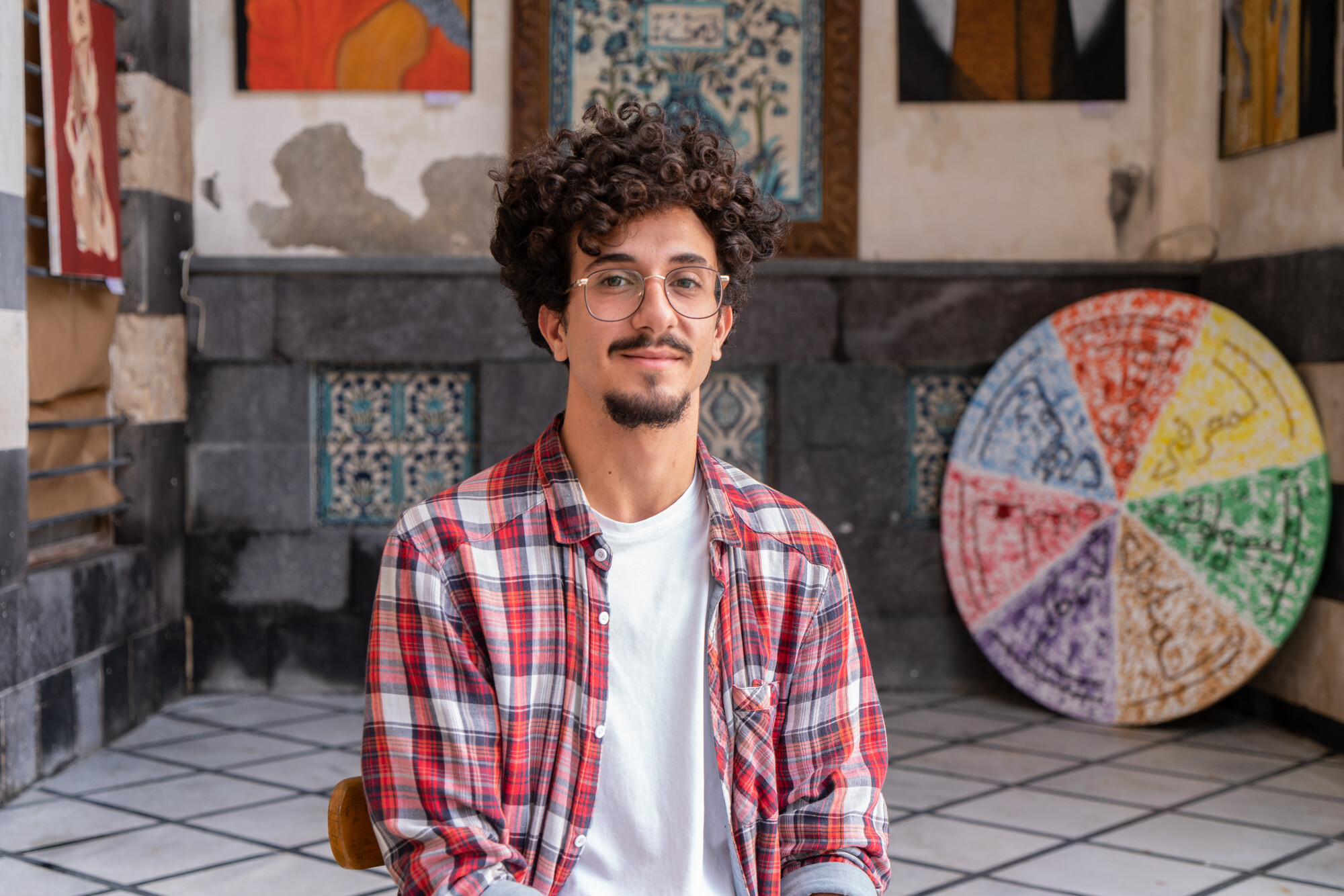 Man sitting at an art exhibit.