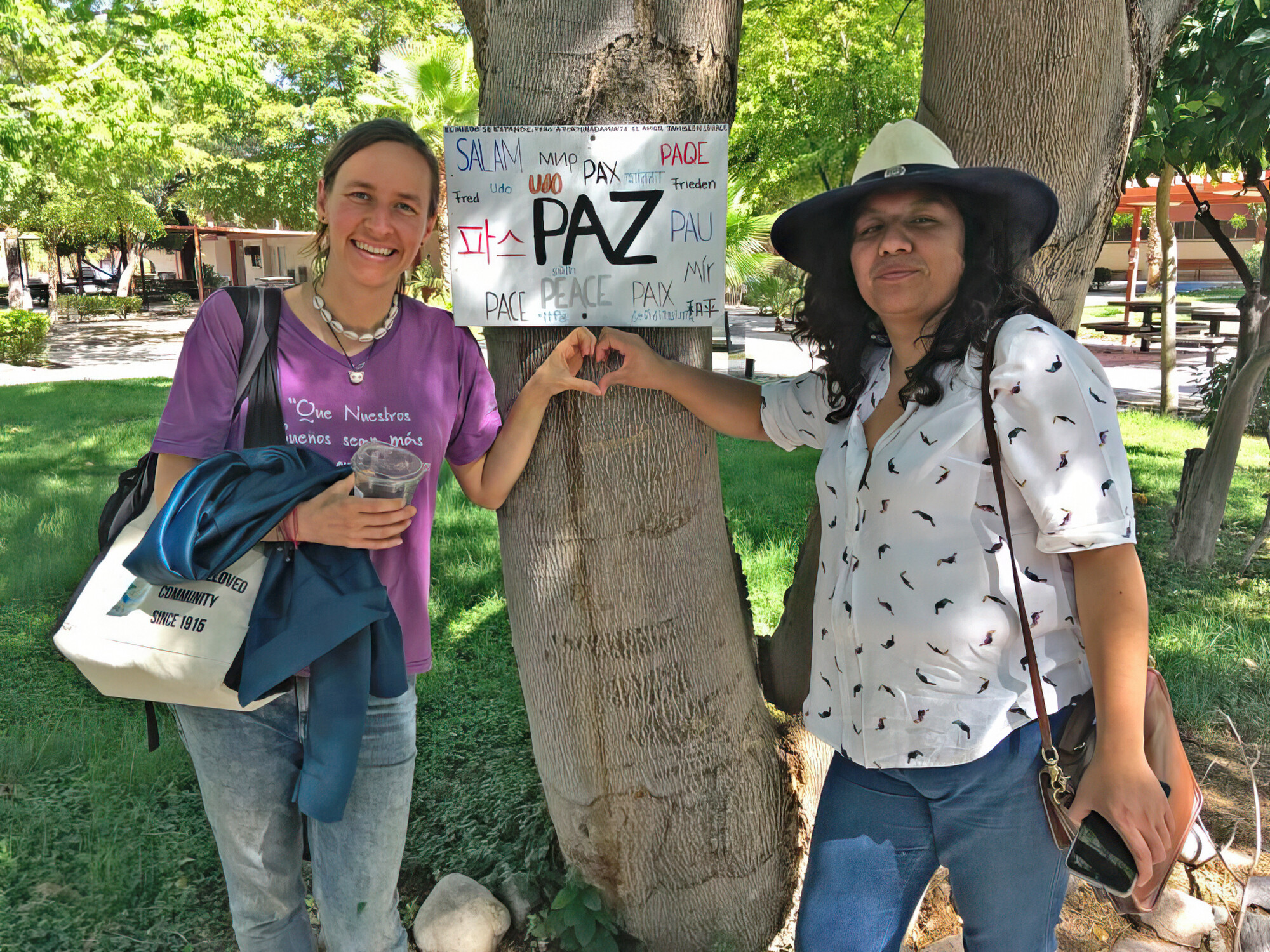 Two women standing with a sign