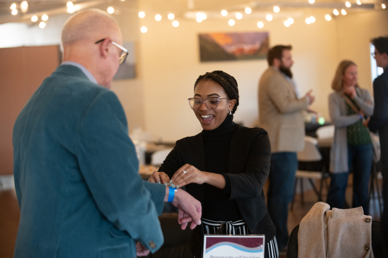 Dorcus Sibanda checks in guests at Skills Auction, a fundraising event for The Conflict Center.