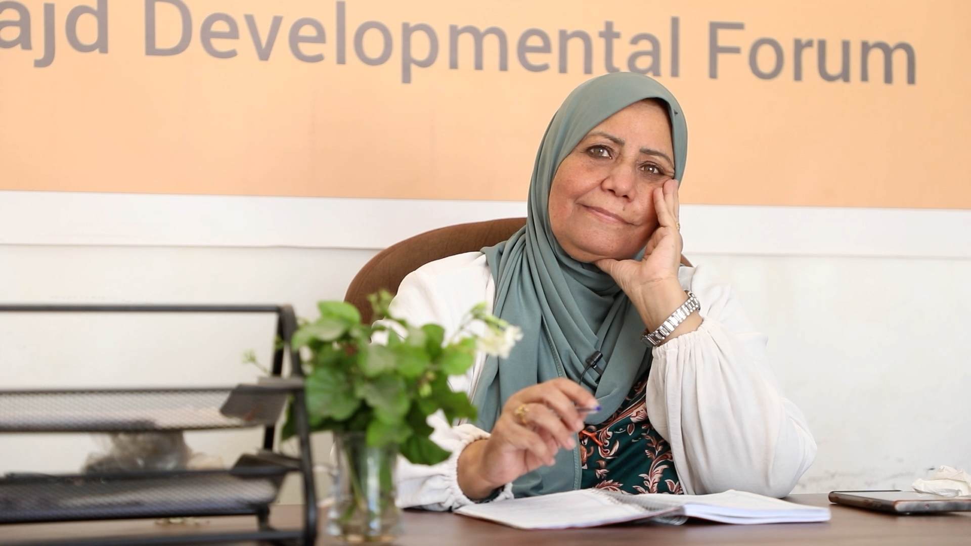 woman wearing hijab sitting at a desk