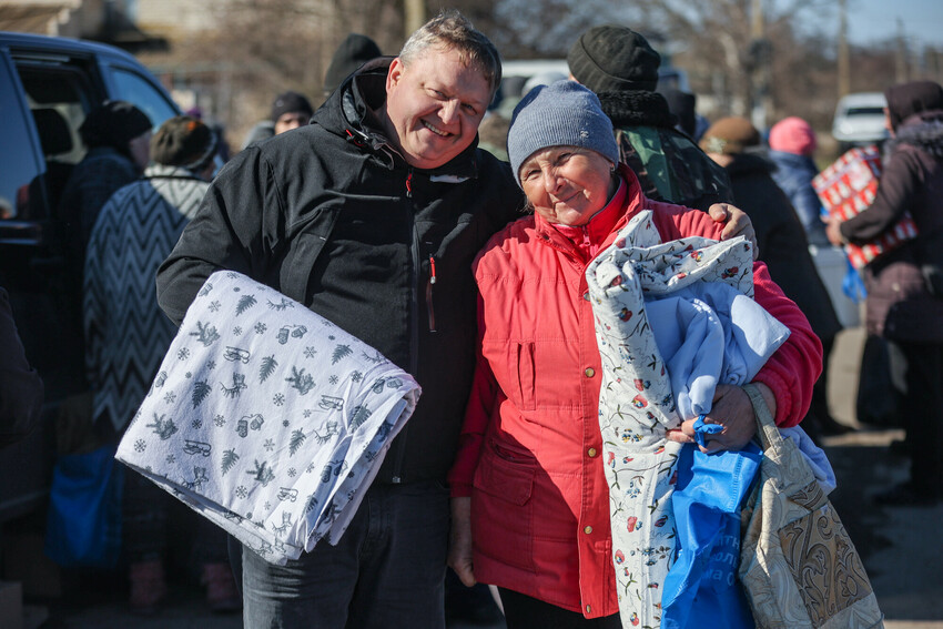 A woman* in a village recovered from Russian military control in Ukraine's Kherson region received essential items, including bedding, from MCC partner Charitable Foundation Uman Help Center (Uman Hel