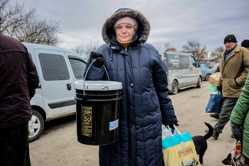 A woman* in a village recovered from Russian military control in Ukraine's Kherson region displays the MCC relief kit she received from MCC partner Charitable Foundation Uman Help Center (Uman Help Ce