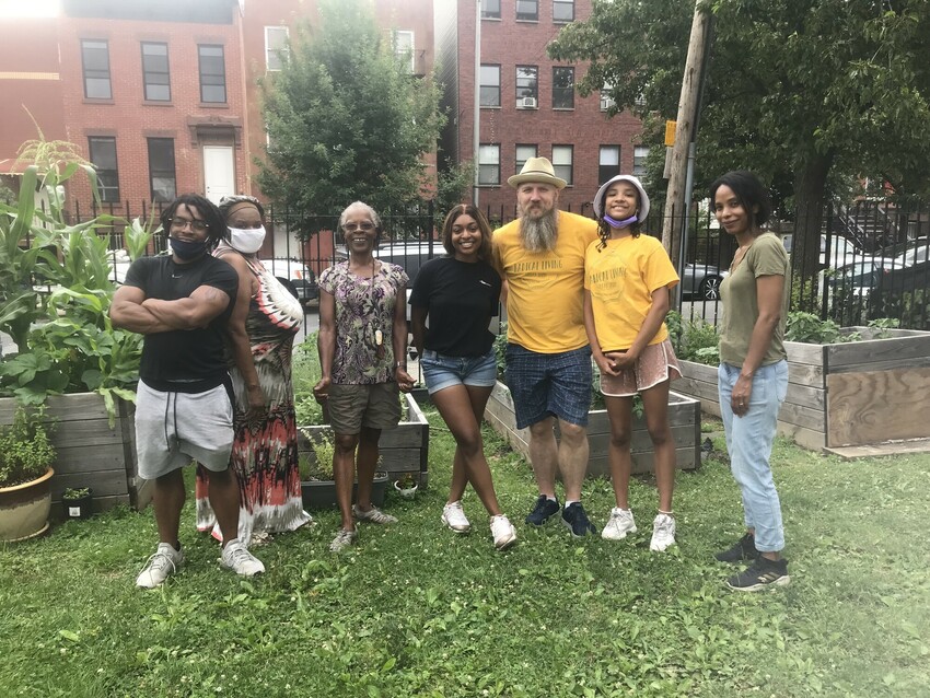 Summer Service worker Peony Nobrega-Walcott (middle) and other Radical Living leaders and participants gather for a photo in front of a church garden during summer camp. During the camp, the leaders t