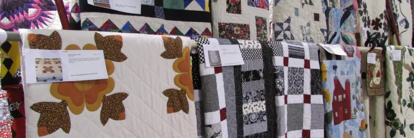 Several quilts on display at an auction
