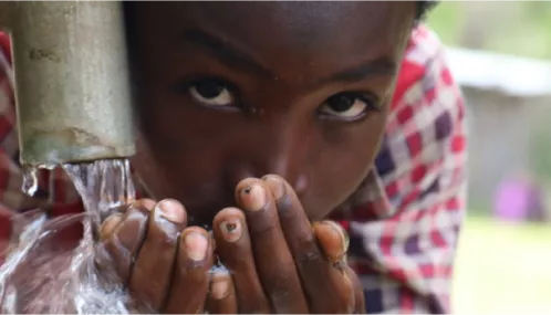 African Child Drinking water out of a pipe