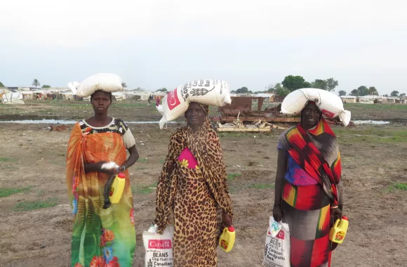 A group of people holding bags of food from Canadian Foodgrains Bank