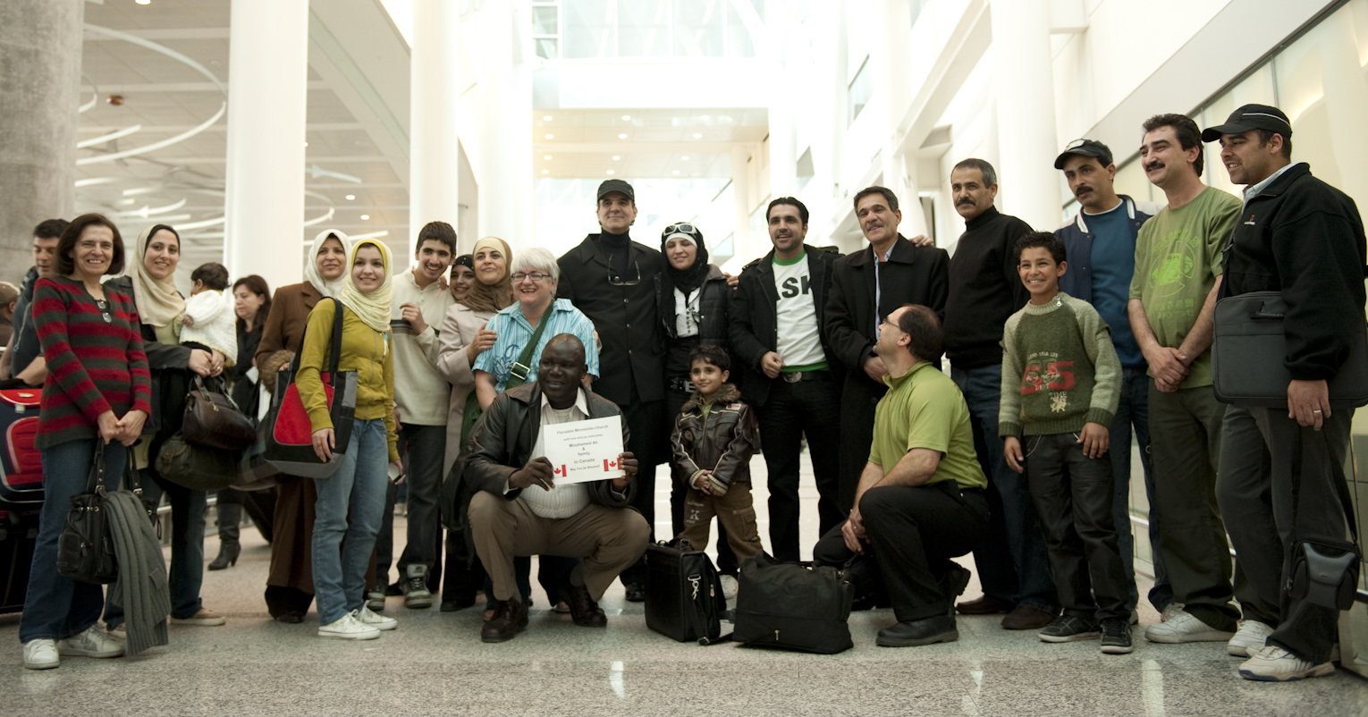 A large group of people pose together at an airport