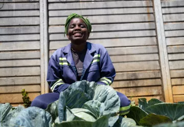 A woman smiling in her gardenthis is the block