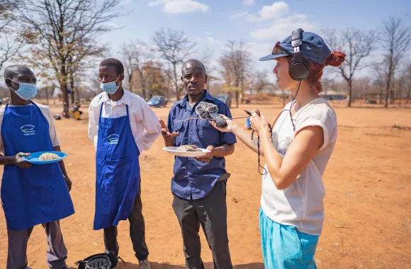 Storyteller recording an interview with men participating in a program from Zimbabwe.