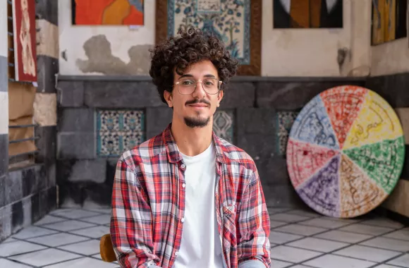 Man sitting at an art exhibit.