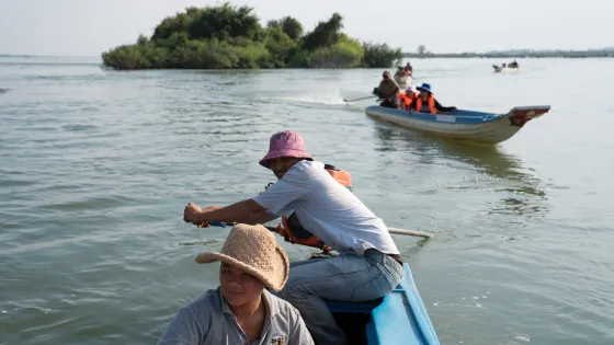 Kun Nora, 32, with Sor Navy, 36, steers the boat on a patrol along the Mekong River as they check for illegal fishing.